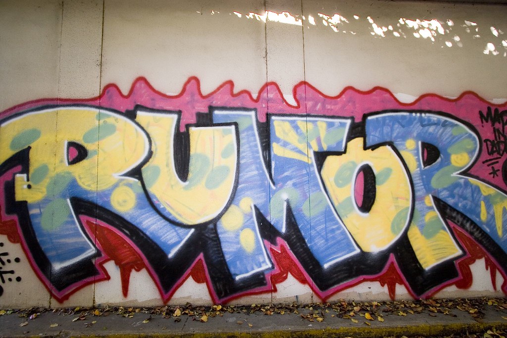 Photo of the word Rumor tagged on a wall.