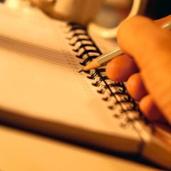 Écrire des notes dans un cahier.